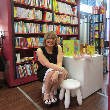 Gemma Pasqual asseguda amb una estanteria de llibres darrere