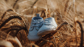 babies shoes on top of wheat