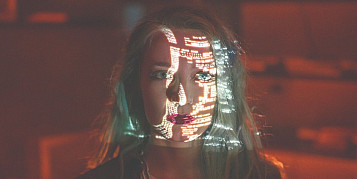 cara de dona iluminada per dades d'un ordinador