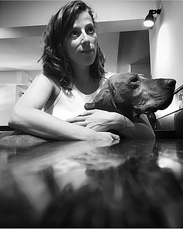 Fanny Hidvegi sitting and hugging a dog in a white and black foto